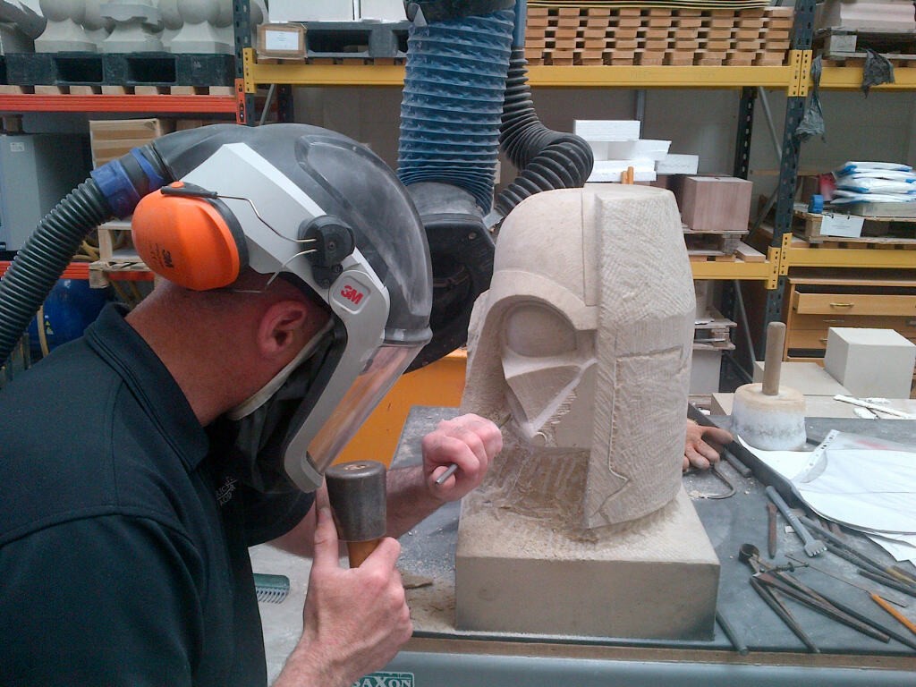 A man carving a Darth Vader grotesque