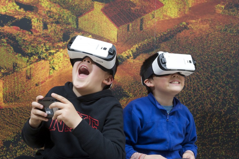 Two children using virtual reality headsets to explore a 3D digital recreation of the Antonine Wall