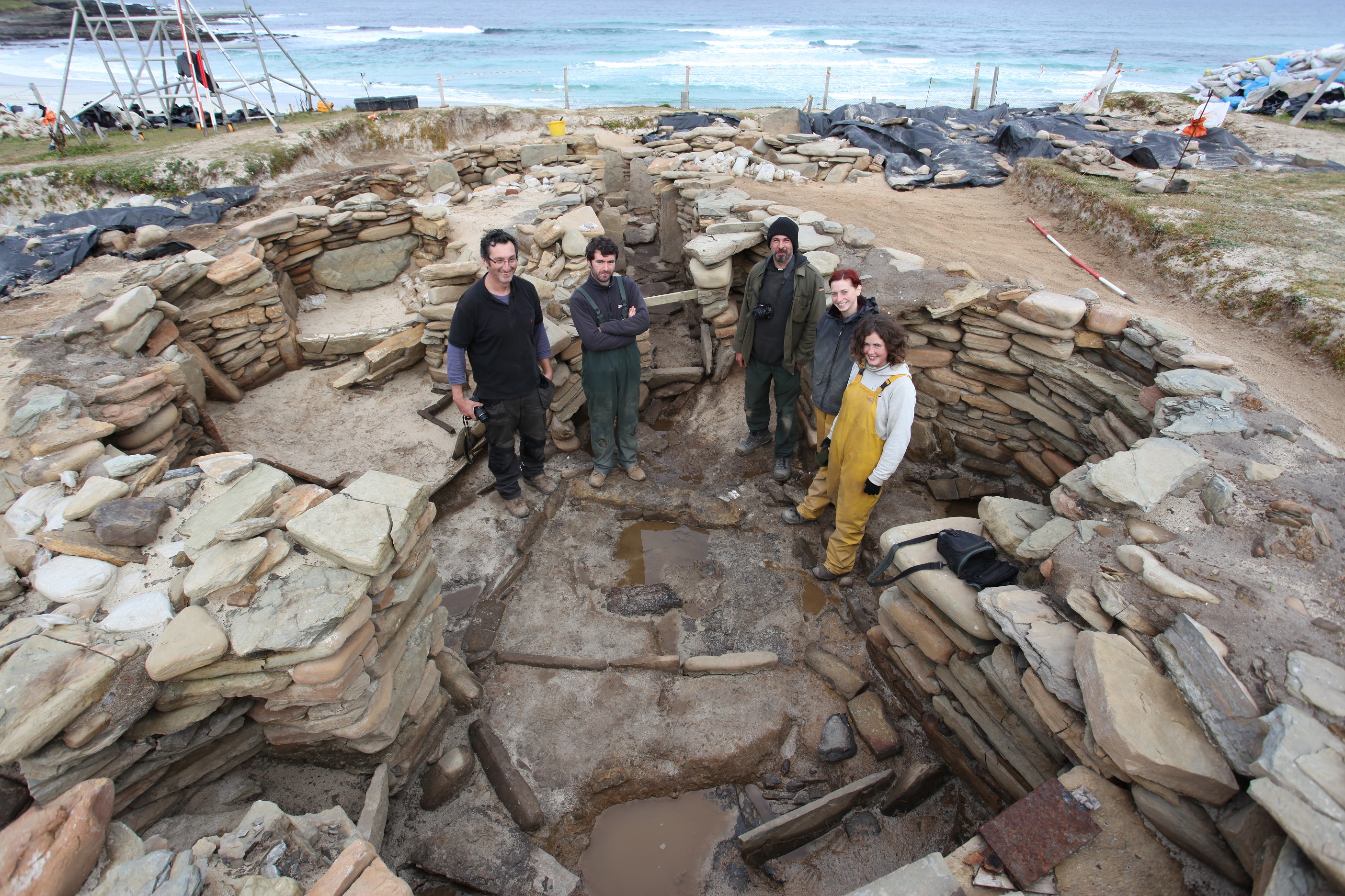 A team of archaeologists standing in an excavated building