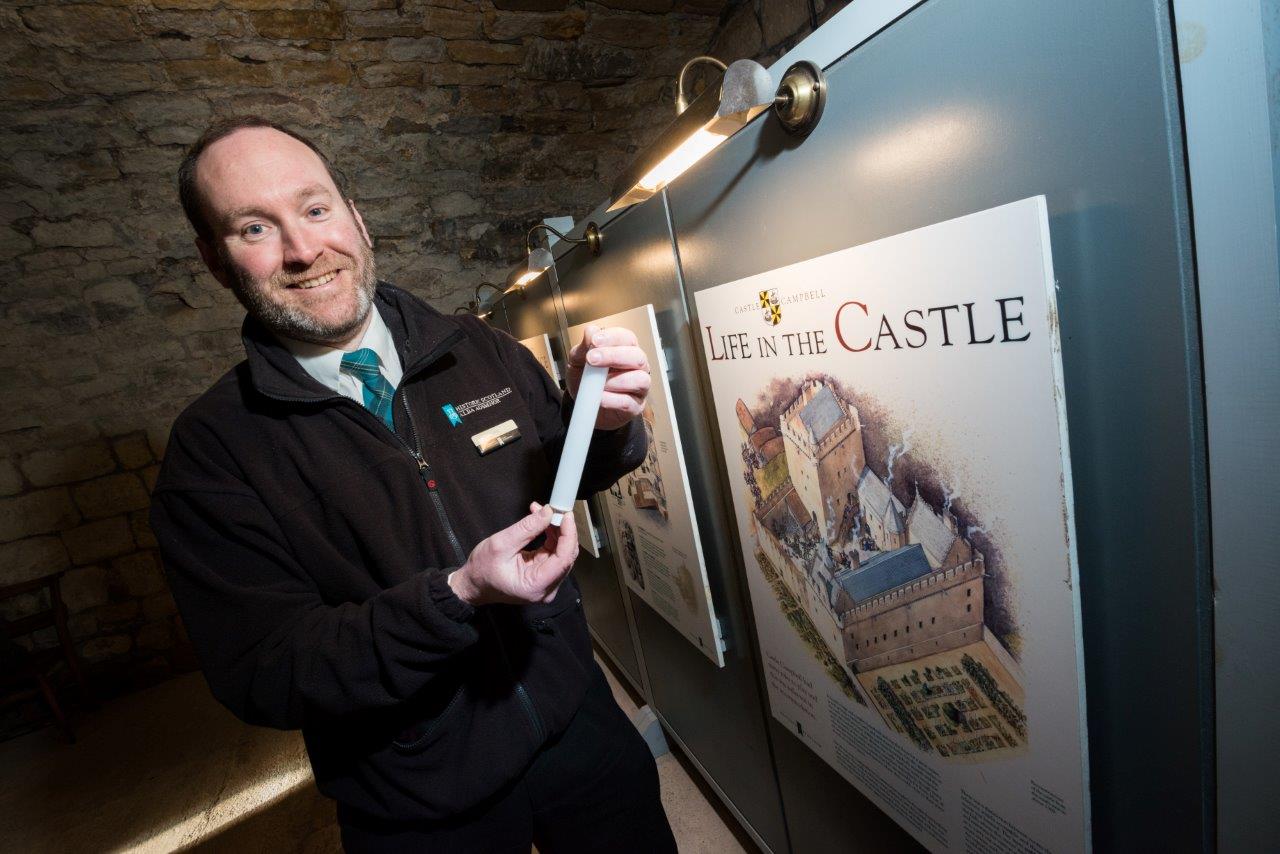 Monument manager Finlay standing in front of an interpretation display lit up with new LED bulbs