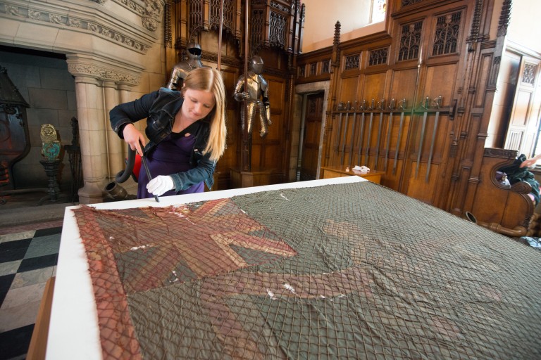 Collections Manager Rachael Dickson carries out some housekeeping work prior to the display of two colours from the Battle of Waterloo, a collaborative exhibition with The Royal Scots at Edinburgh Castle