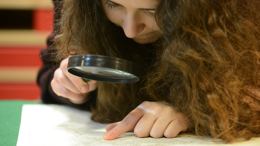 A girl looking at an old record in the HES collections