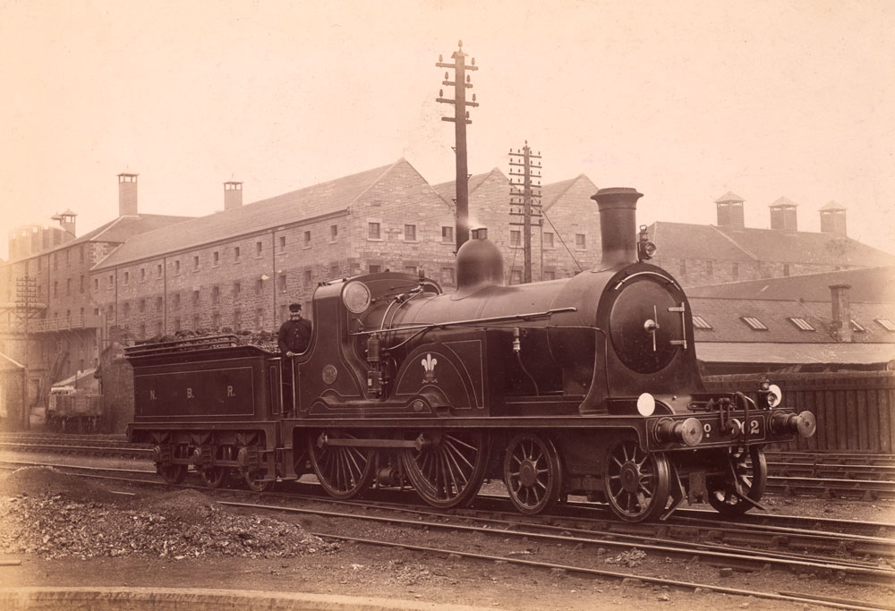 An old photograph of a steam locomotive on rails.