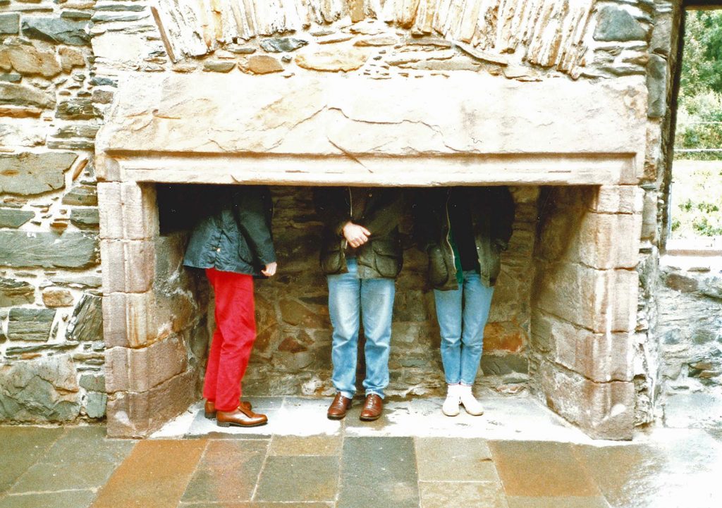 old fireplace with three people inside with only their legs visible