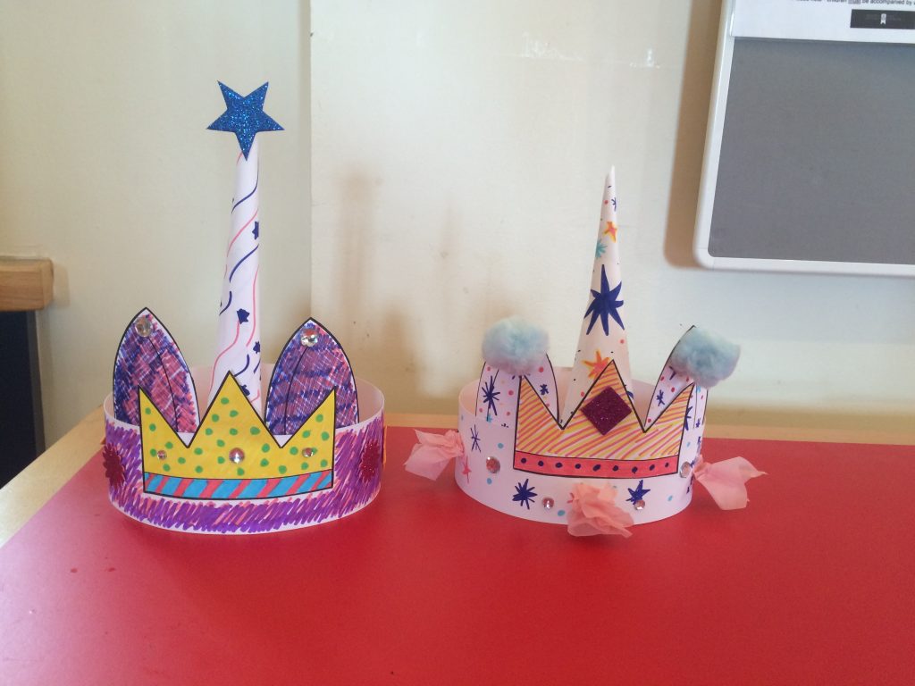 two paper crowns with unicorn horns in the middle