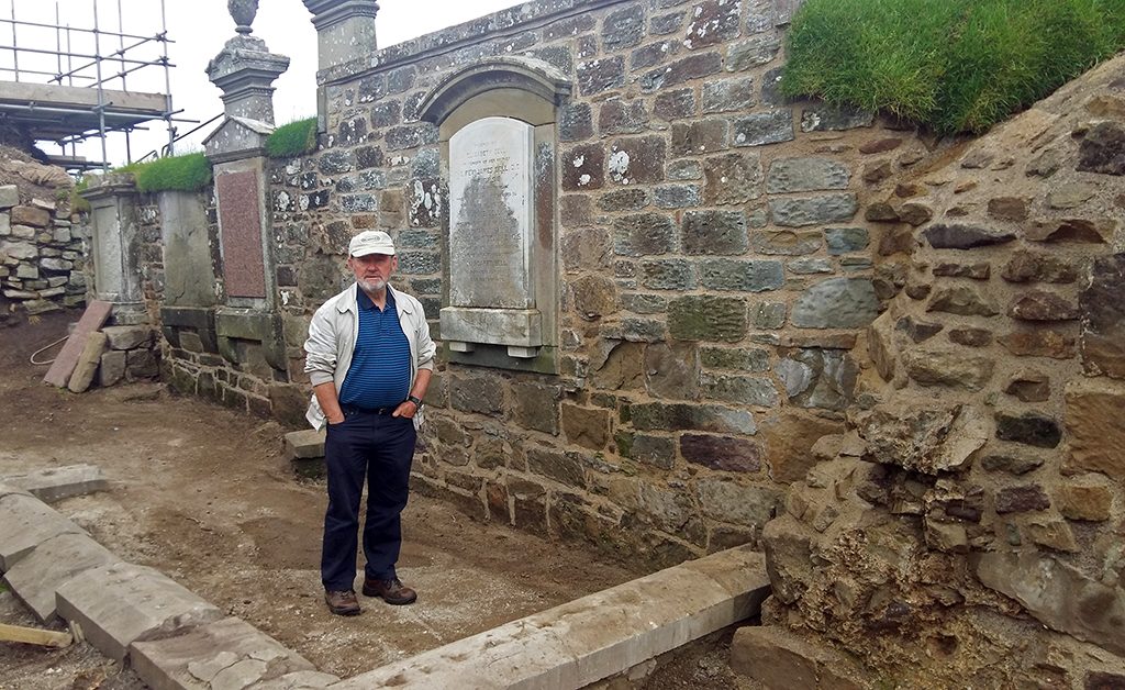 man stands in front of recently repaired wall