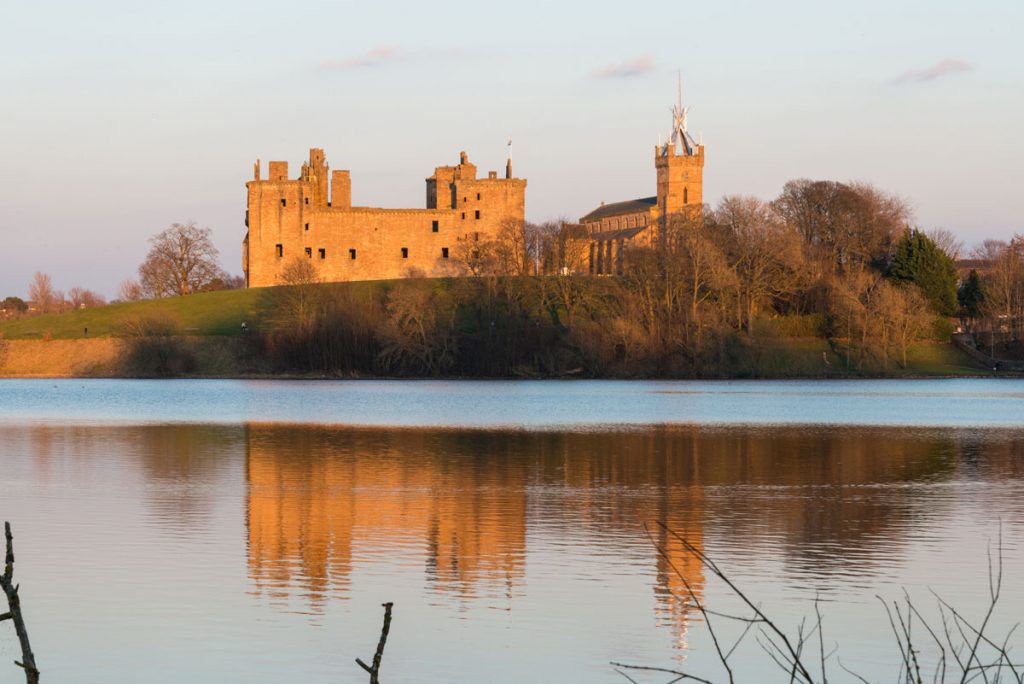 Image of an ancient palace on the banks of a loch at sunset 