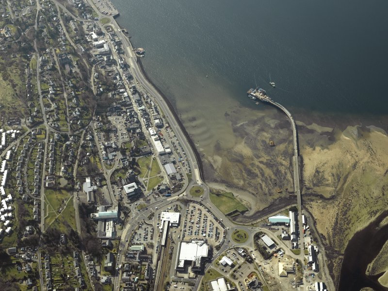 aerial view showing coast line with lots of buildings including a railway depot, church, pier and hospital,