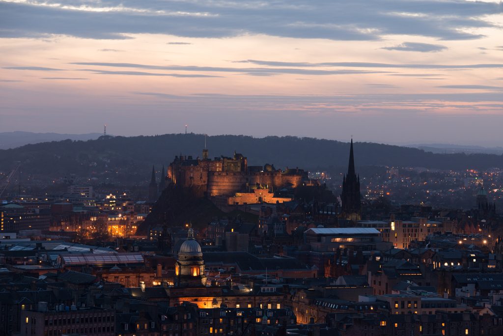 city skyline with castle at the centre with lights twinkling in the twilight