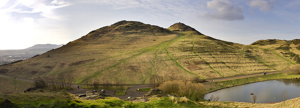 sloping green hill with ridges cut into the side, once used for growing crops