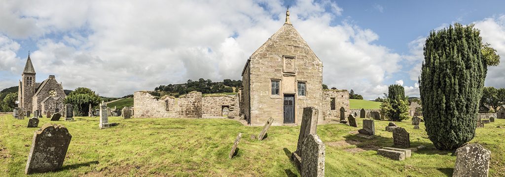 panorama showing a church building with graveyard in front