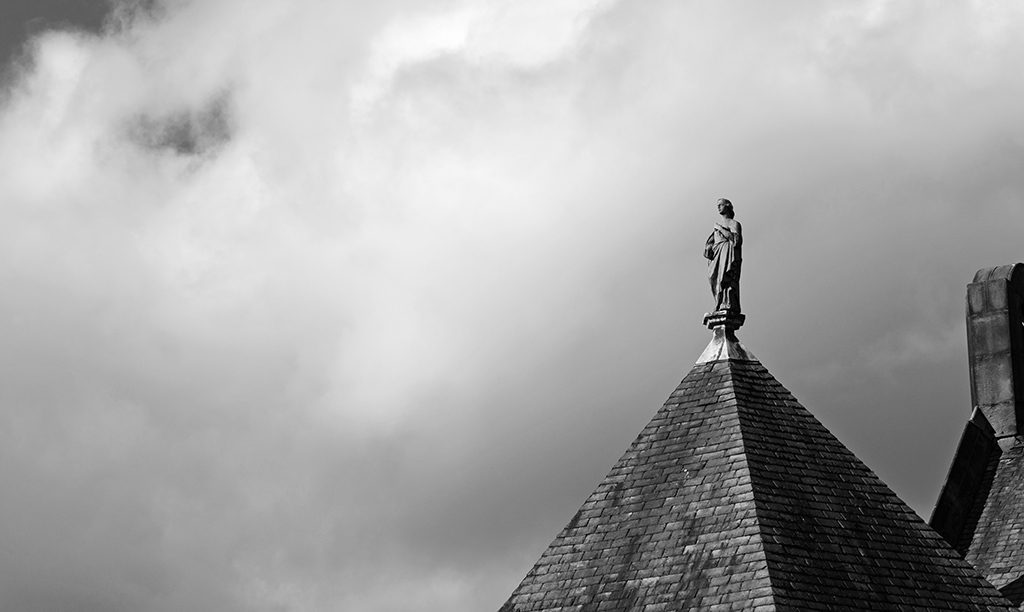rooftop with a statue on top of a woman facing away from the camera