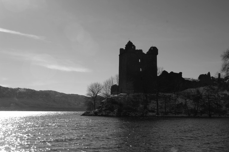 tower silhouetted against the sky with water in front of it