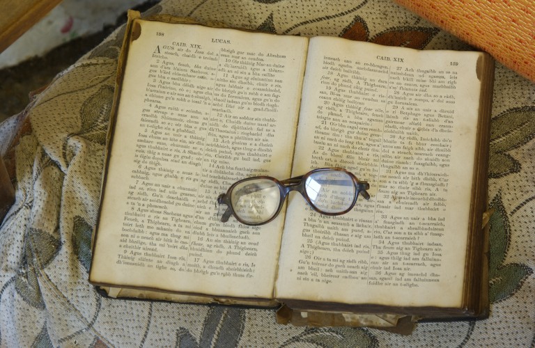 old book sitting open with a pair of glasses on top