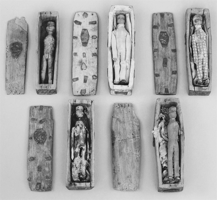 five miniature coffins with remains of dolls inside