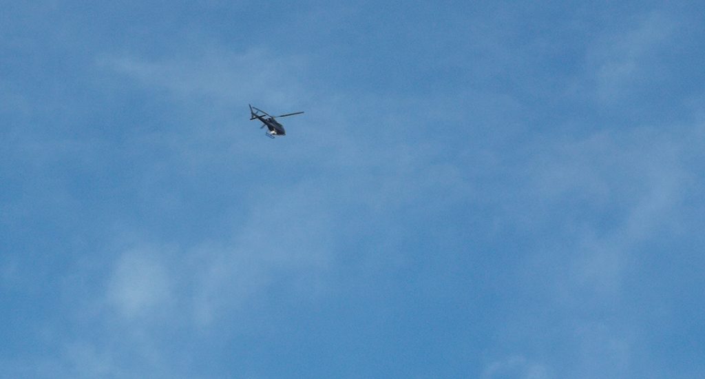 blue sky with a helicopter visible high above