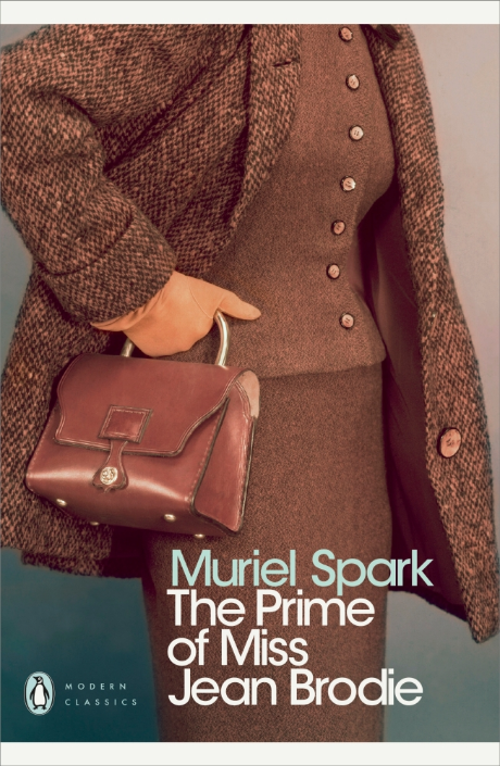 book cover showing a woman from shoulder to knee dressed in brown tweed suit and coat and carrying a brown handbag