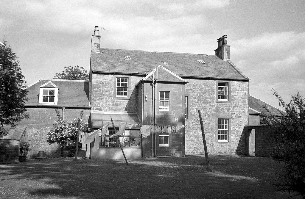 black and white photo of a house with a washing line in front of it