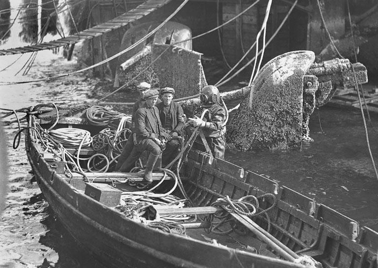 black and white image of divers in a boat