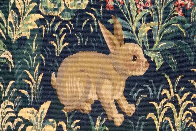 stitched rabbit surrounded by leaves and grass