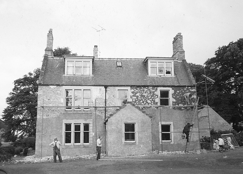 Workmen working on a three story house.