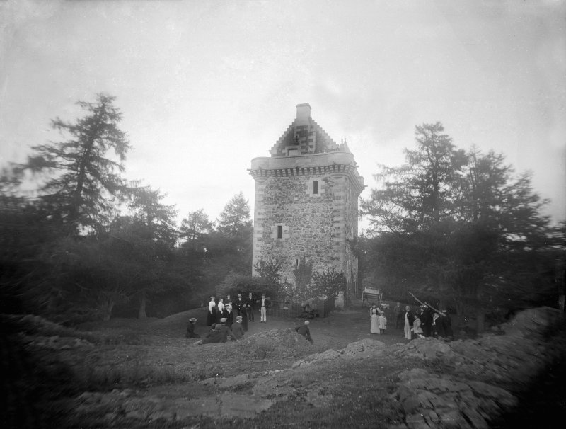 View of Fatlips Castle from 1898 with groups of people in Vitroian dress stood outside