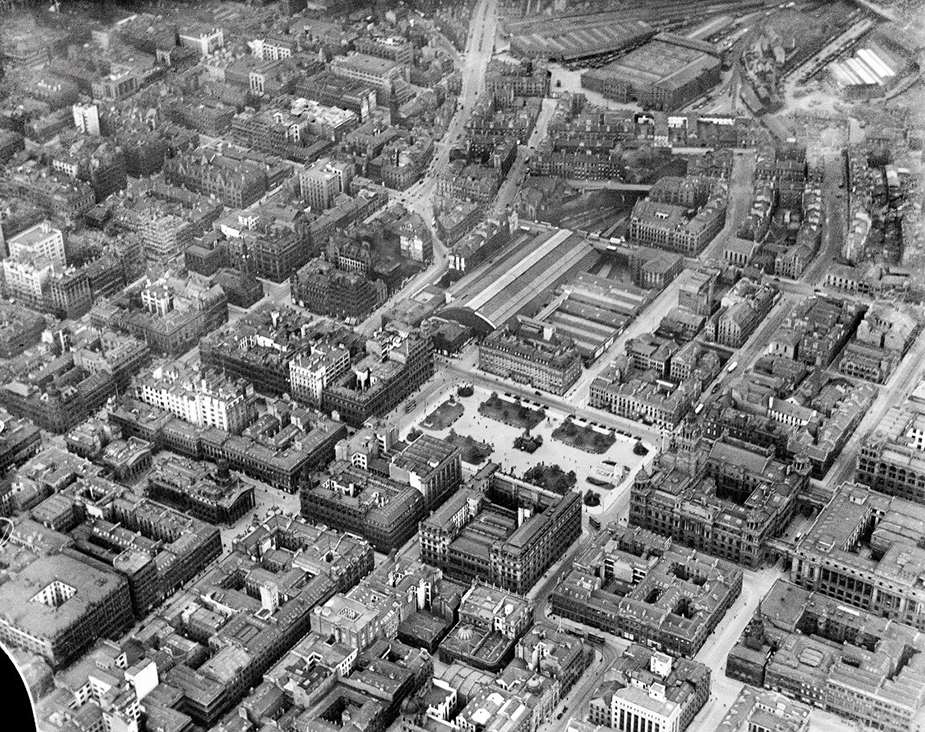 black and white view from above showing city buildings set out in a grid pattern