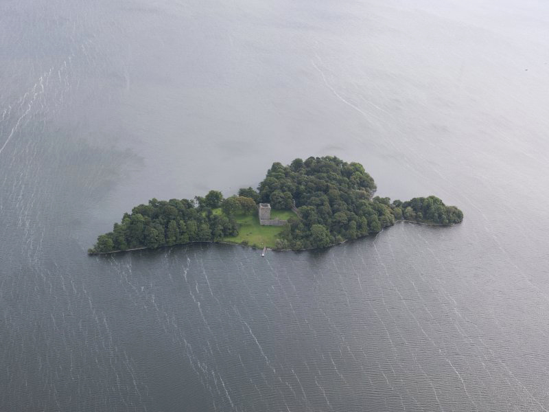 aerial view of an island covered in trees with a castle in the middle