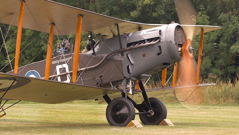 A Bristol Fighter in a field with propeller spinning 