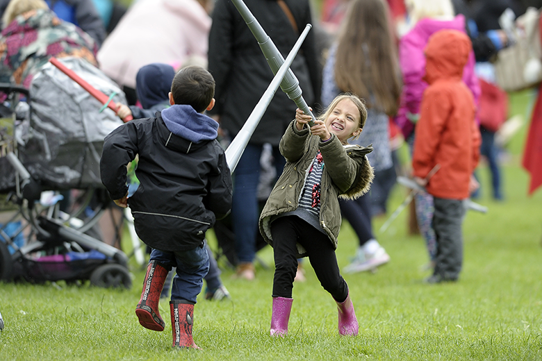 Two young children play at sword fighting