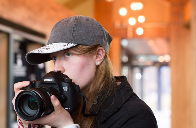 Image of a girl holding a large digital camera during Silver Arts Award