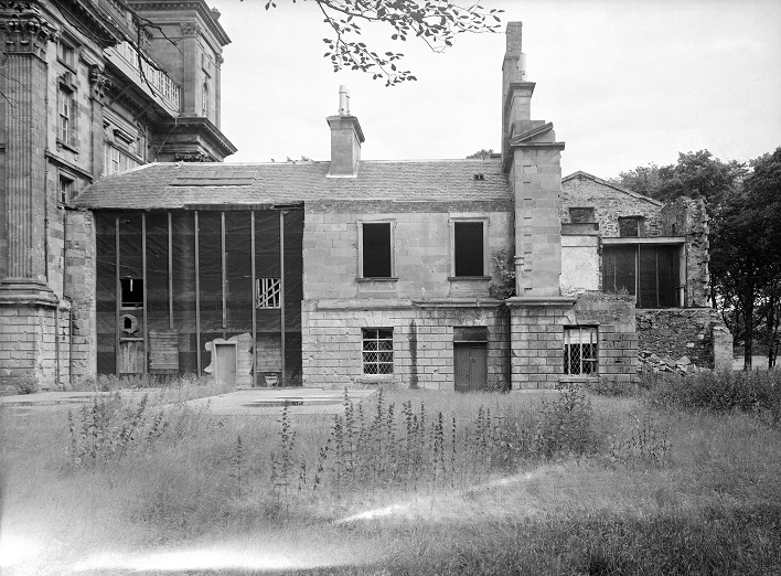 black and white photo of 2 story building in state of disrepair
