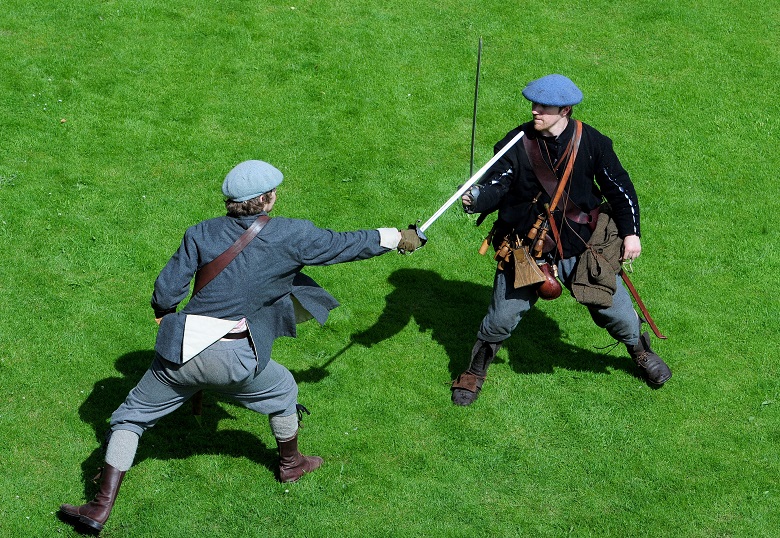 Two men dressed as Covenanters act out a swordfight