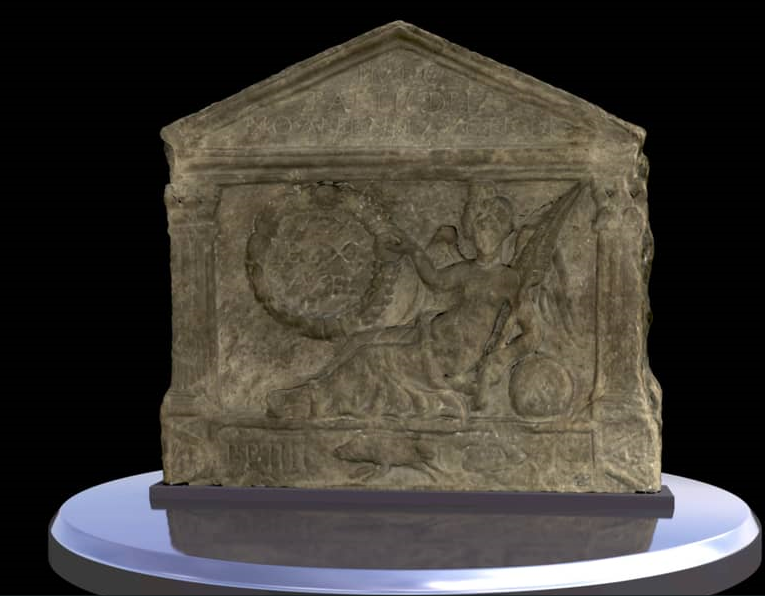 A stone distance slab found along a Roman wall. It is rectangular in shape with a pointed top. There is an intricate carving of a goddess and a boar. The sides of the slab have been carved to look like columns and a roof. 
