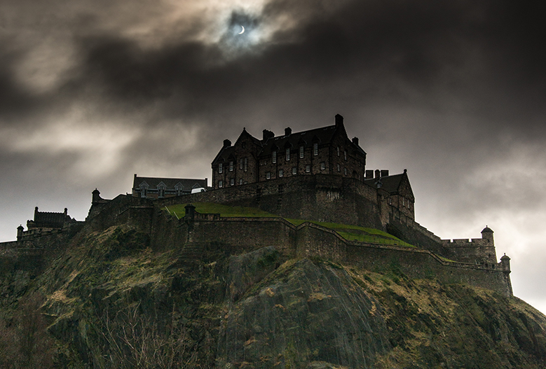 view of edinburghcastle looking spooky during an eclipse