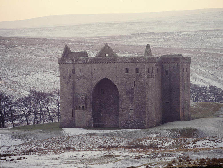 Wintry view of the imposing, hulking Hermitage Castle