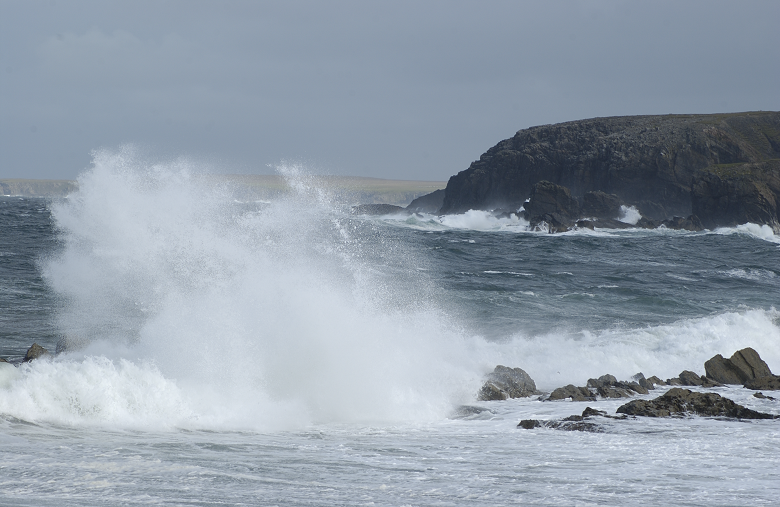 waves crashing on a rugged rock