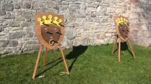 Two wooden quoit games placed in the grounds of a castle. 