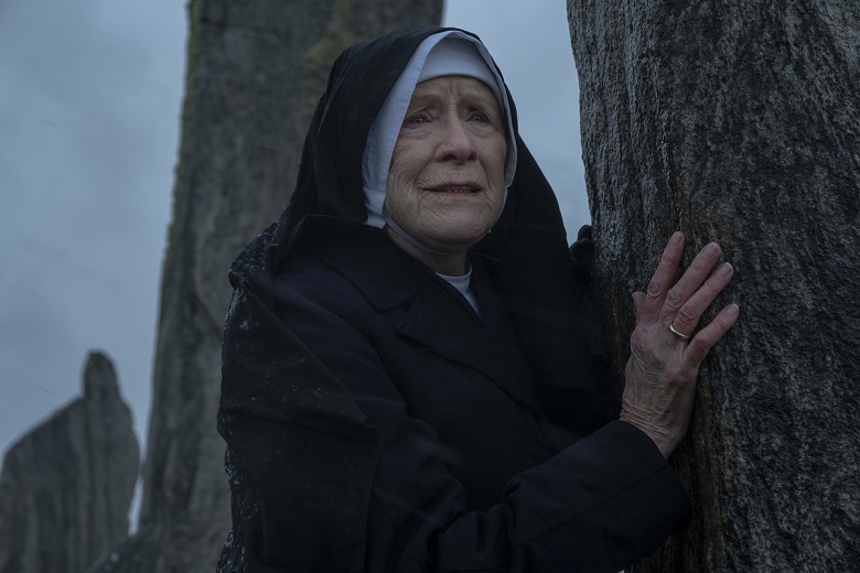 Still from an episode of Call the Midwife showing a nun next to one of the Calanais standing stones