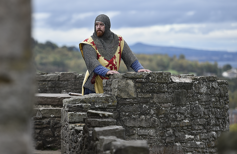 Man dressed as Robert the Bruce on castle battlements