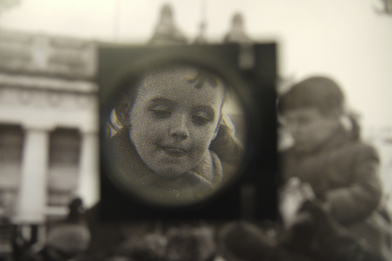 A magnifying glass being used to inspect a photo for publishing