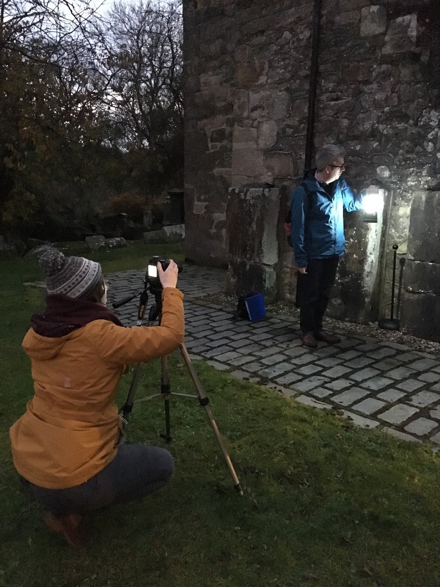 A pair of community group members identifying gravestone markings in Cumbernauld. 