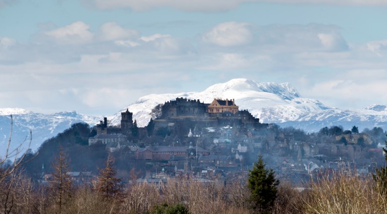 Stirling Castle flanked by snowcapped mountains