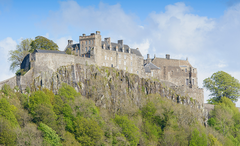 Stirling Castle sitting on its volcanic rock against a blue sky