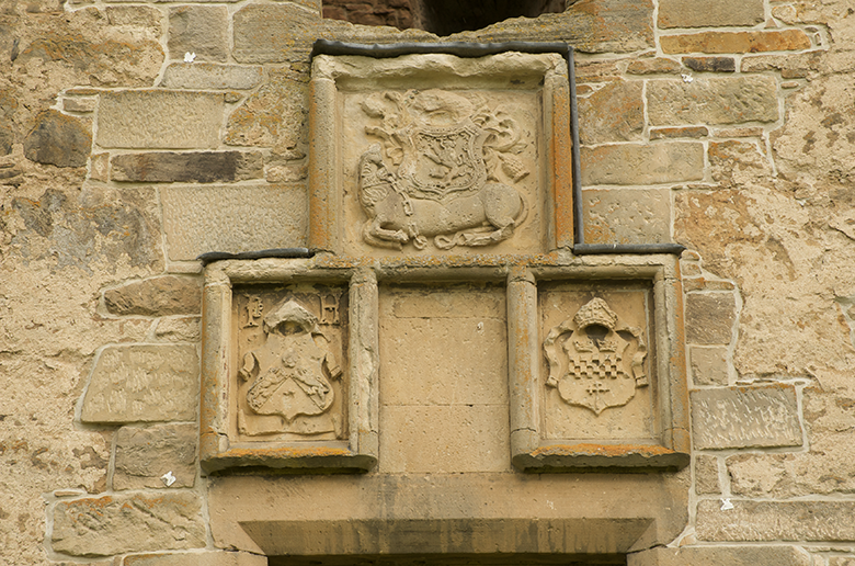 heraldic symbols carved above a doorway, including a unicorn with a shield