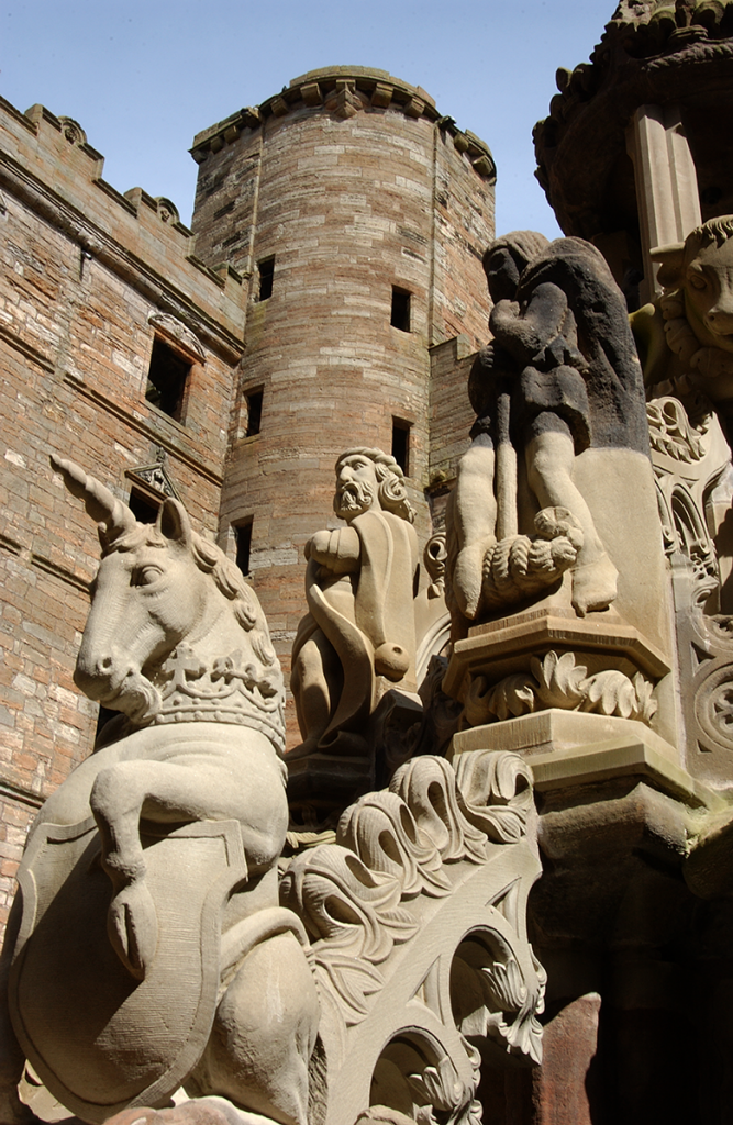 view looking up at the carved stone fountain, which features a carved unicorn