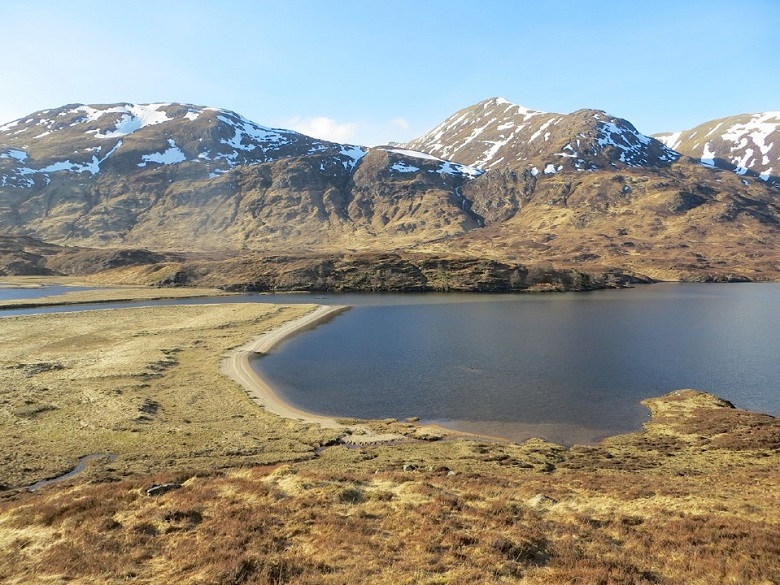 A photo of a loch in Glen Affric, flanked by snow-capped peaks