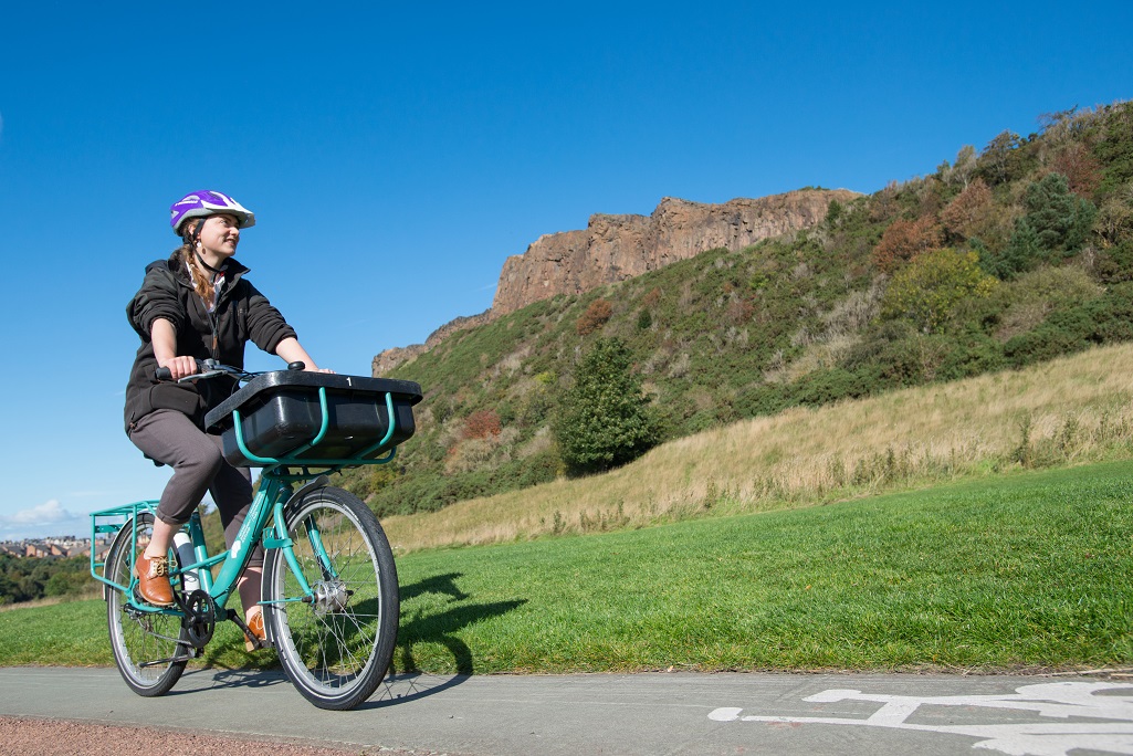 A HES employee cycling through Holyrood Park