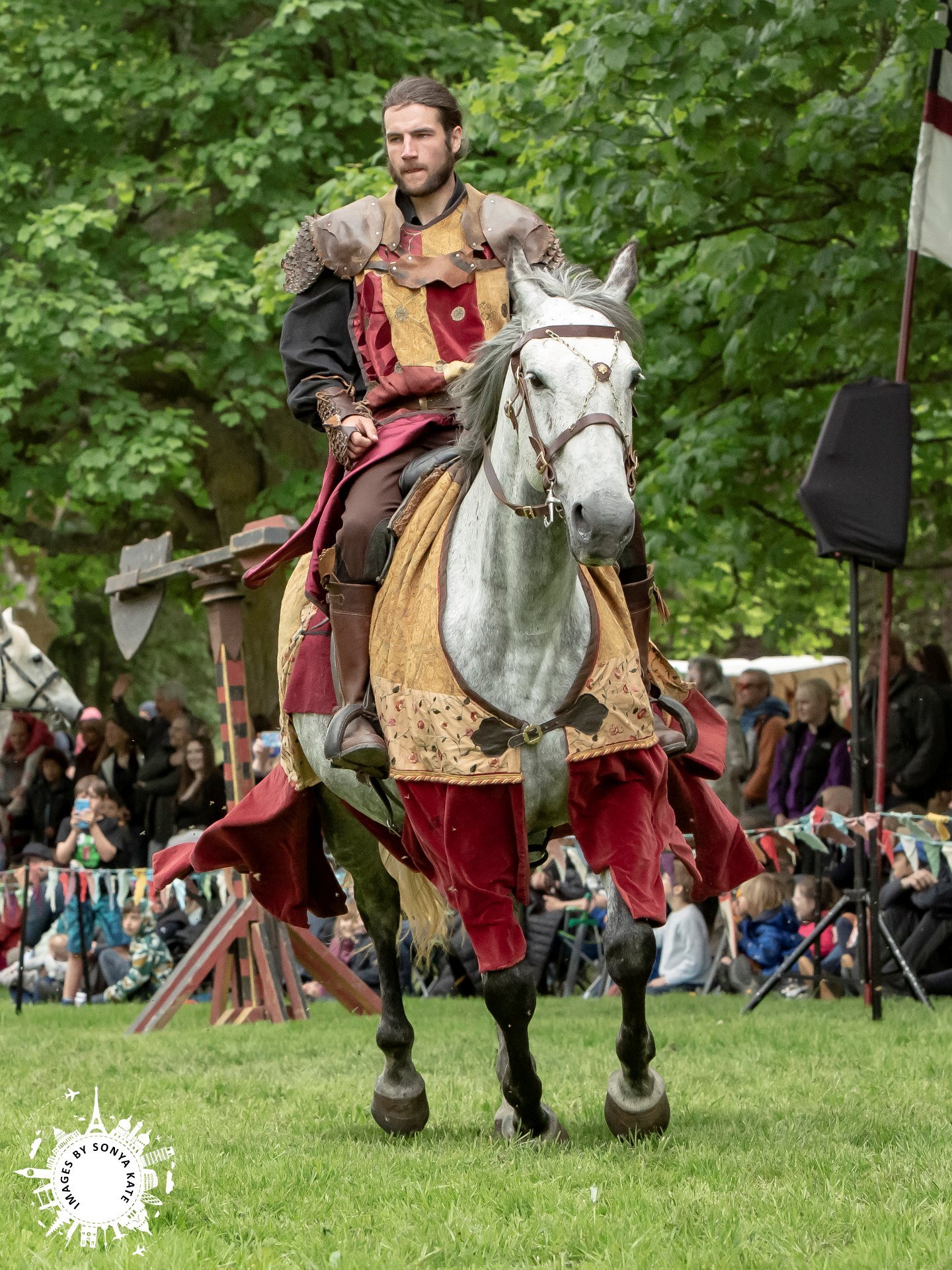 A bearded person sitting on a horse 