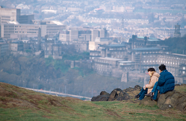 View from the top of Arthur Seat with visitors enjoying the view over Edinburgh